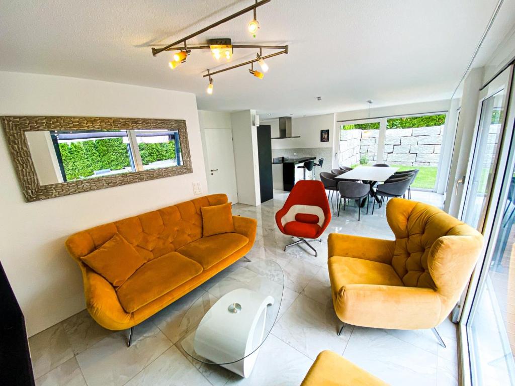 uma sala de estar com um sofá, cadeiras e uma mesa em Cozy Escape House 12 min away from Zurich Main Station em Ober Urdorf