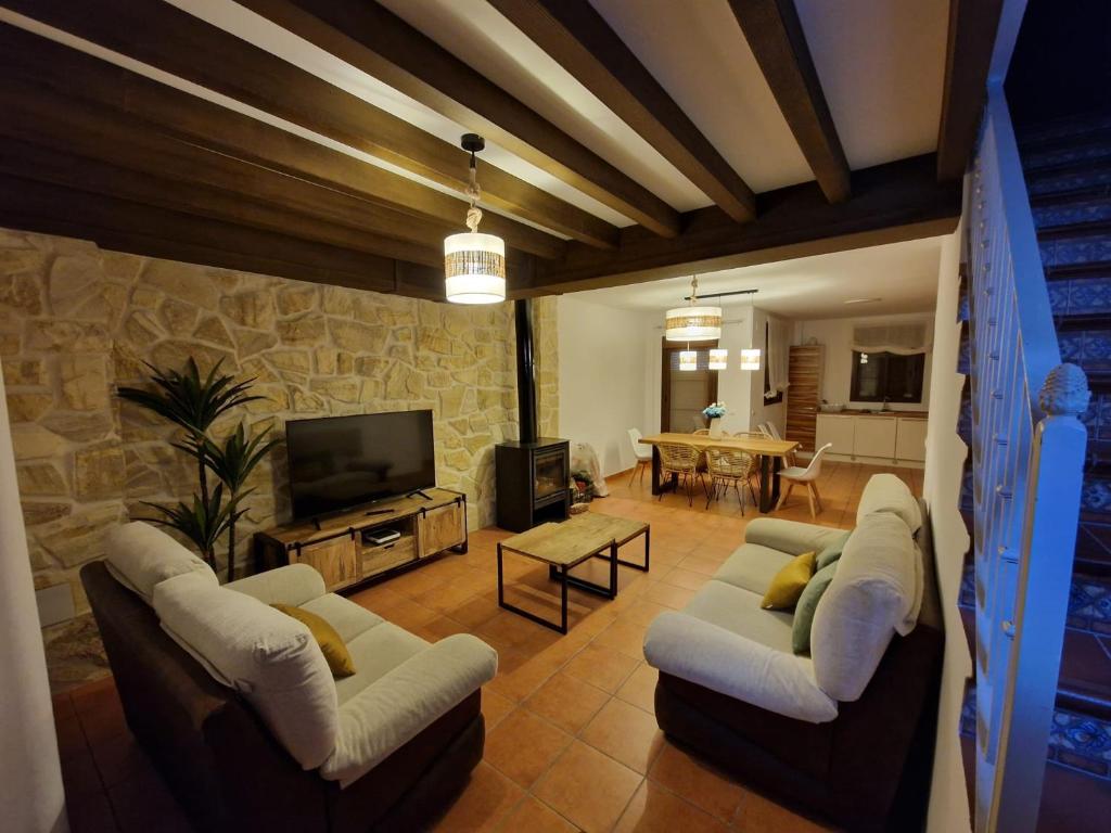 a living room with two couches and a tv at La Magia de Grazalema in Grazalema