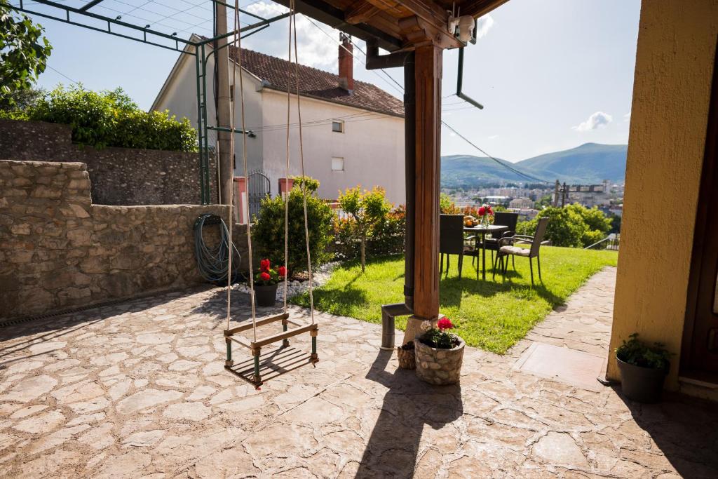 eine Terrasse eines Hauses mit einem Tisch und Stühlen in der Unterkunft Apartman Emina in Mostar
