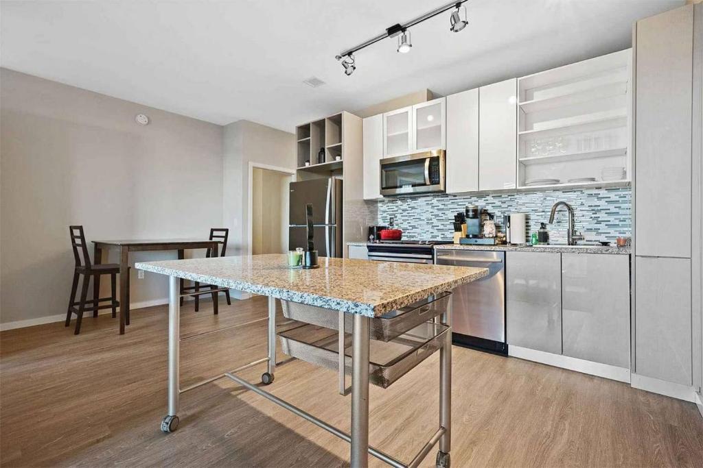 a kitchen with a table in the middle of a room at Sleek downtown Cleveland apartment in Cleveland