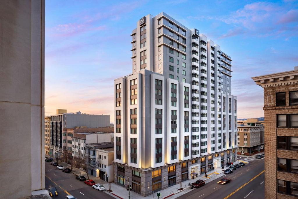 オークランドにあるAC Hotel by Marriott Oakland Downtownの市道の白い高い建物の描写