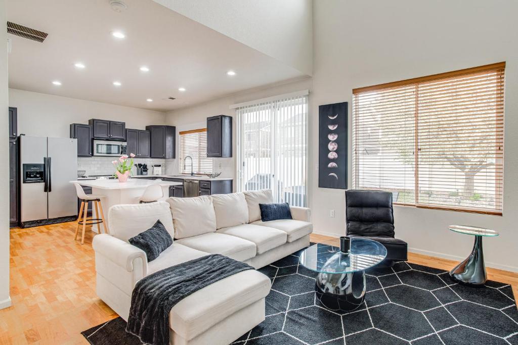ein Wohnzimmer mit einem weißen Sofa und einer Küche in der Unterkunft Inviting Denver Home with Yard about 6 Mi to Airport! in Aurora