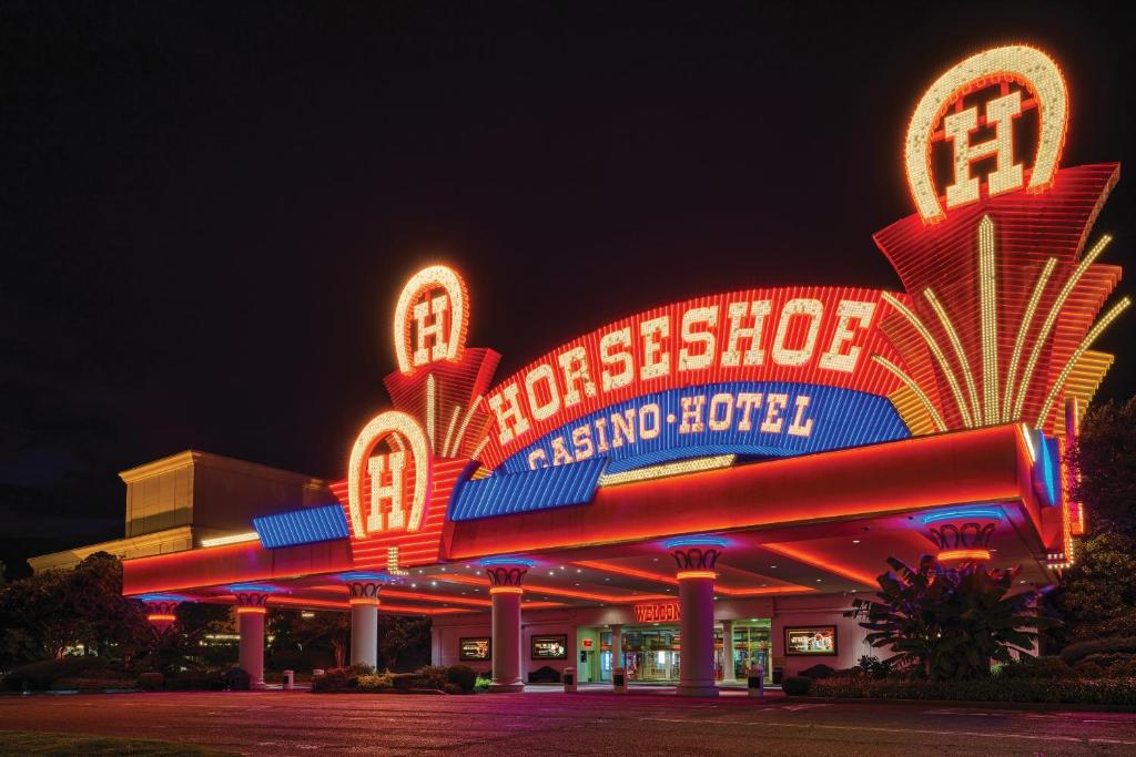 a large building with neon signs at night at Horseshoe Tunica Casino & Hotel in Tunica Resorts