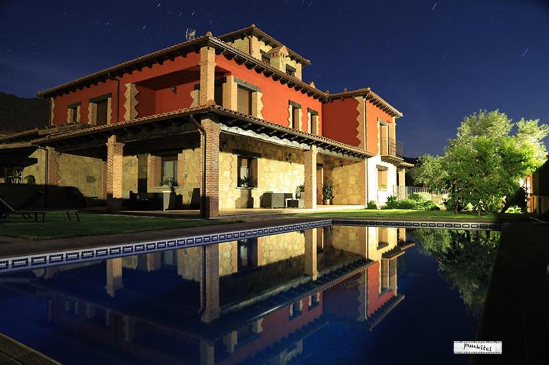 una casa grande con piscina frente a ella en Casa Rural La Canchalera en Losar de la Vera