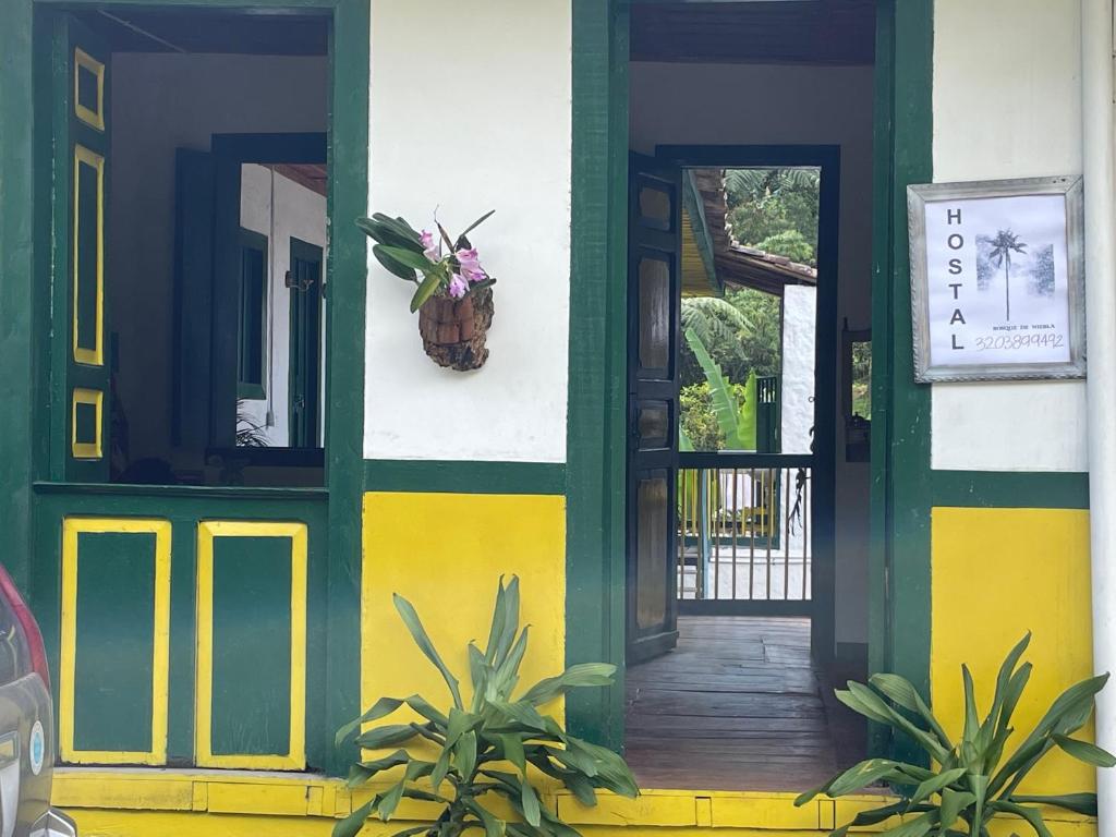 a house with a green and yellow front door at BOSQUE DE NIEBLA in Pijao