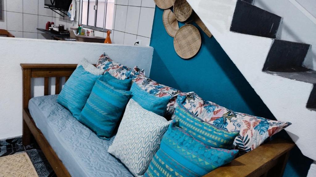 um sofá com almofadas azuis num quarto em AEROHOSTEL Brasil em Guarulhos