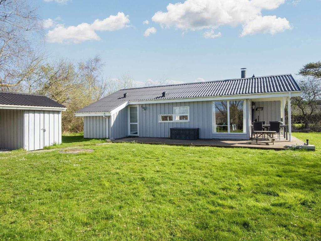 uma pequena casa branca com um grande quintal em 8 person holiday home in Ebeltoft em Ebeltoft