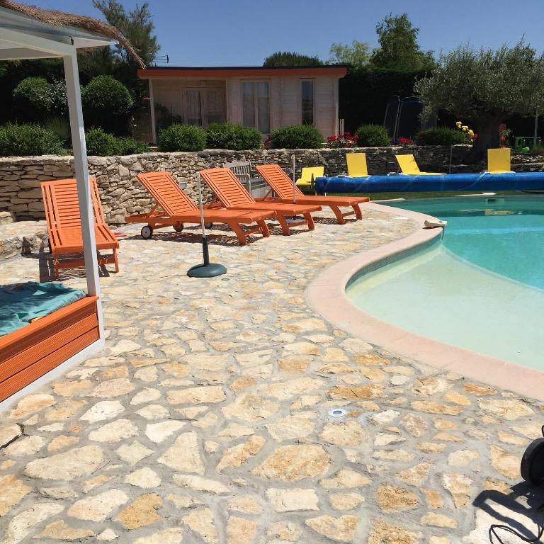 a group of chairs sitting next to a swimming pool at Le Domaine de Charline de 1 à 35 personnes in Issel