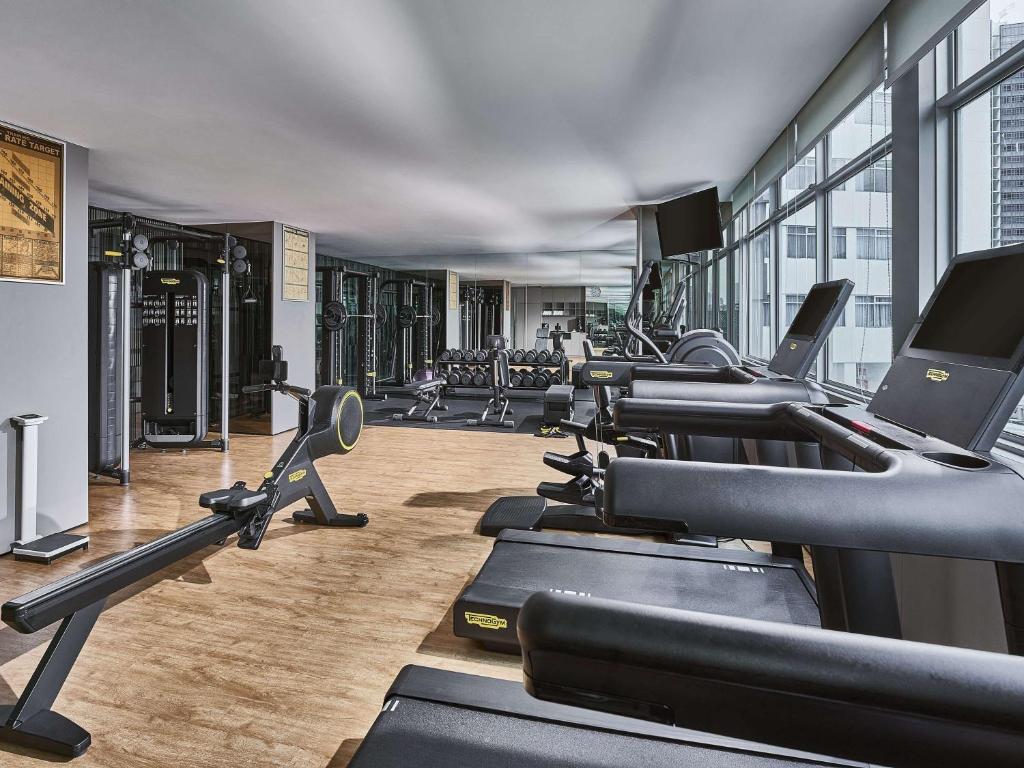 un gimnasio con filas de cintas de correr y máquinas en Novotel Singapore on Kitchener en Singapur