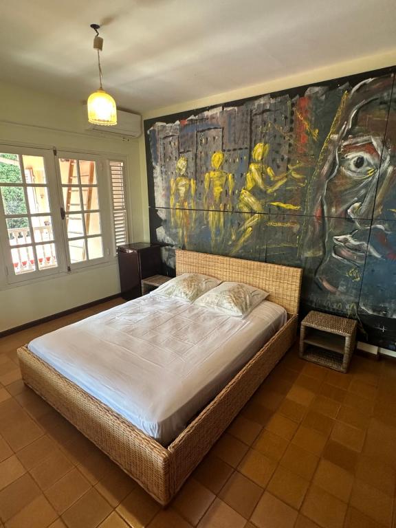 a bedroom with a large painting on the wall at Between us : Chambres d’hôtes à Saint joseph in Saint-Joseph