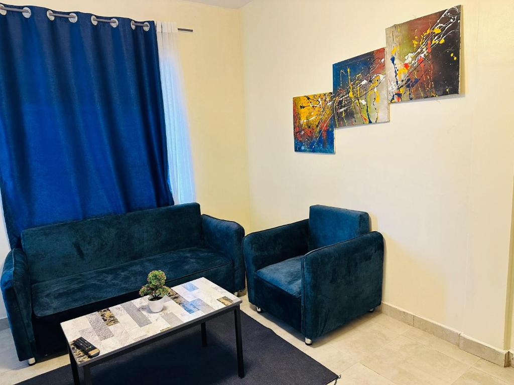 a living room with two chairs and a coffee table at Central Residence - 1 Bedroom Kigali in Kigali