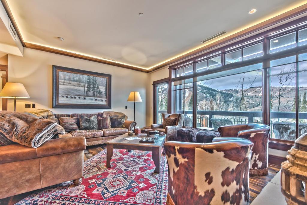 a living room with leather furniture and a large window at Year Round Recreation Luxury Resort Amenities and Hot Tub Access! Deer Valley Arrowleaf 211 in Park City
