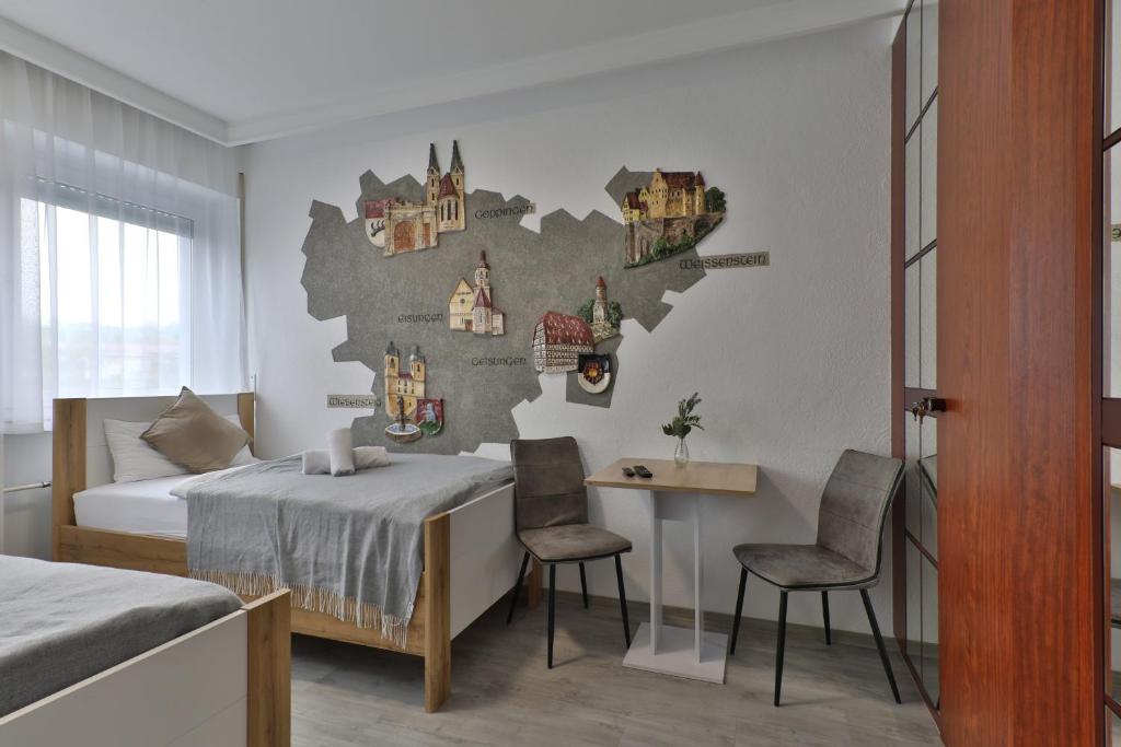 um quarto com uma cama, uma mesa e cadeiras em Moderne Ferienwohnungen - Service wie im Hotel em Göppingen