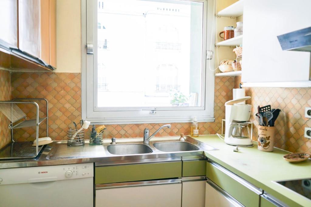 a kitchen with a sink and a window at Cozy 58 m near Butte-aux-Cailles in Paris