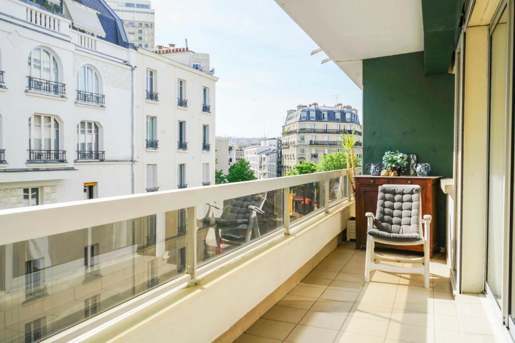 a balcony with a chair and a view of a city at Cozy 58 m near Butte-aux-Cailles in Paris