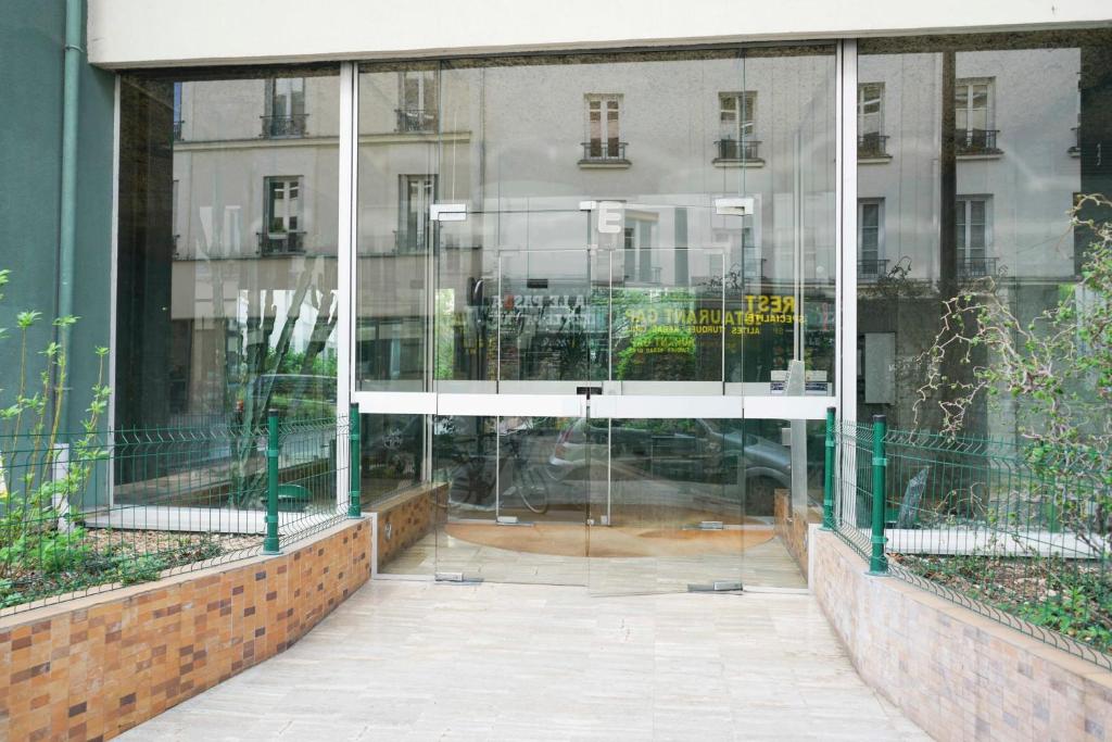 a reflection of a building in a glass window at Cozy 58 m near Butte-aux-Cailles in Paris