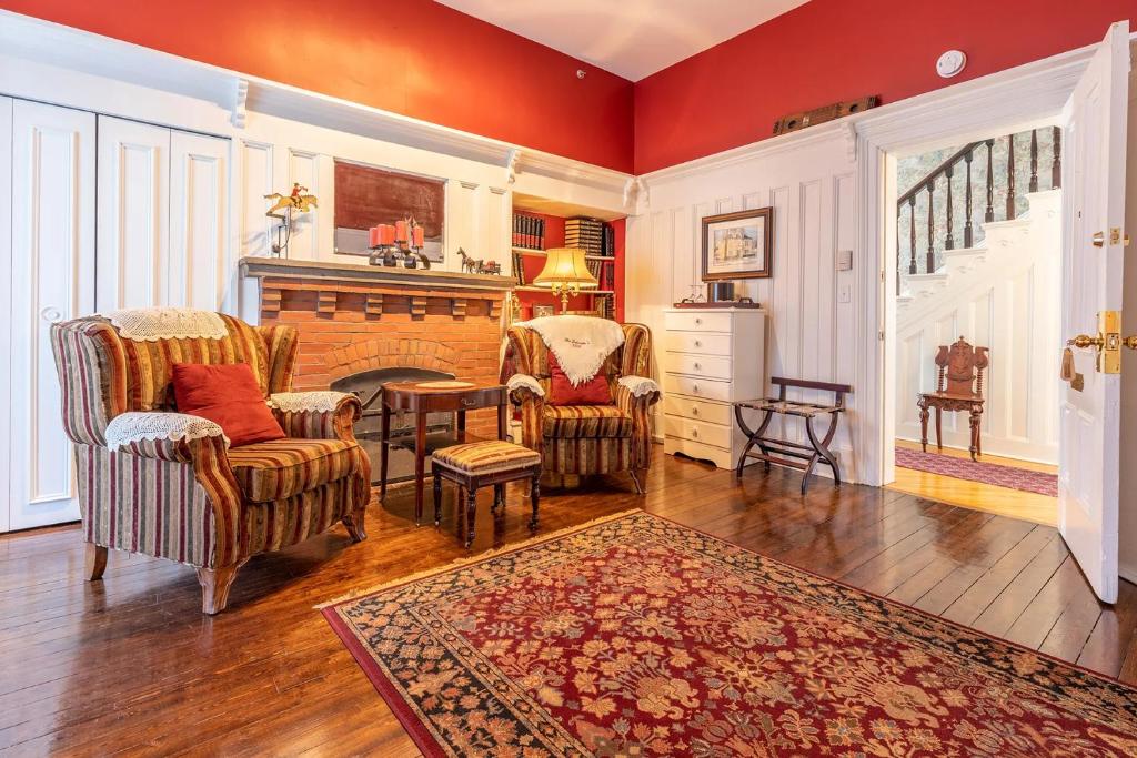 a living room with two chairs and a fireplace at Fitzroy Hall in Charlottetown