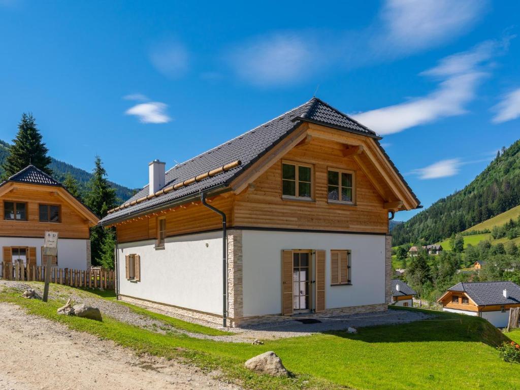 ein Haus mit einem Holzdach auf einer unbefestigten Straße in der Unterkunft Haus Elau in Donnersbachwald