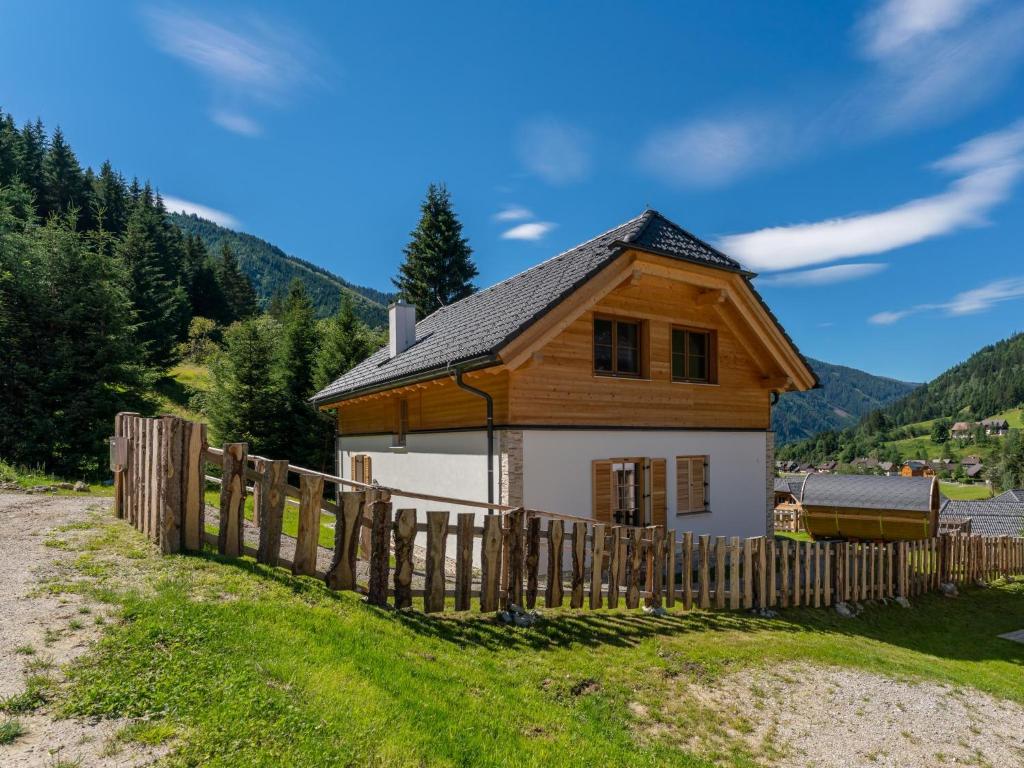 uma casa com uma cerca de madeira em frente em Bergzauber em Donnersbachwald