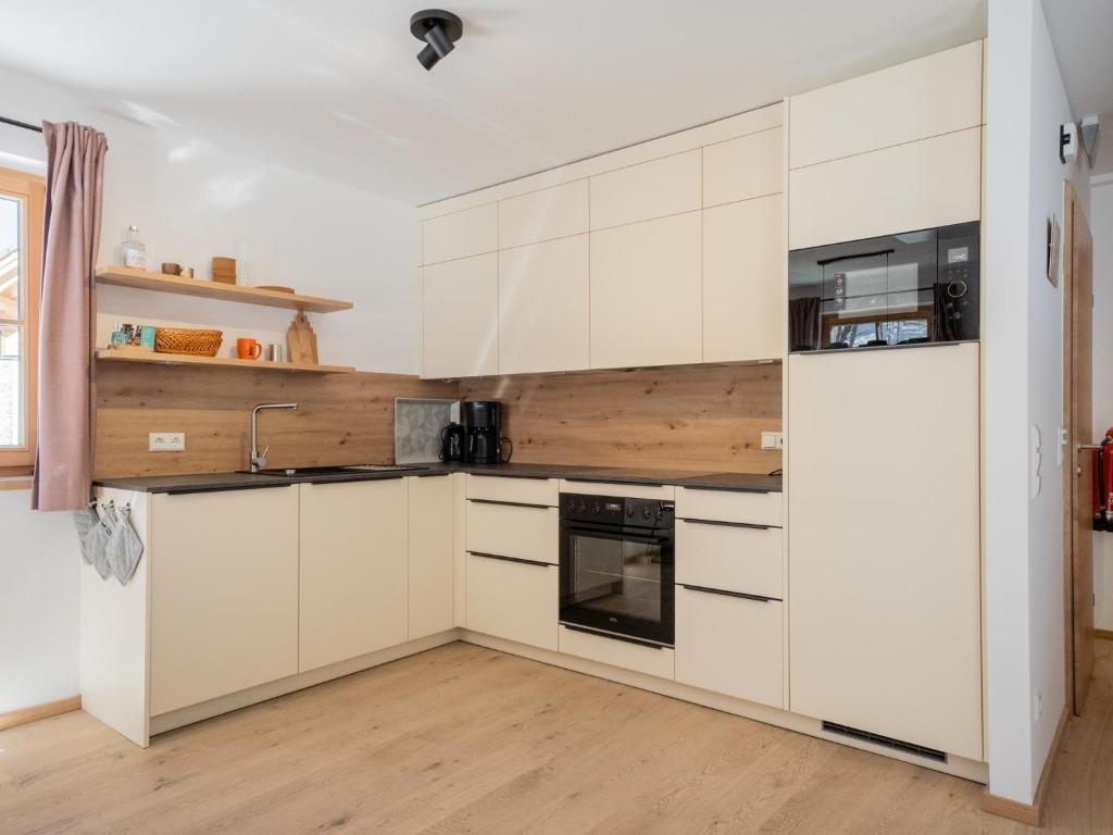 a kitchen with white cabinets and a refrigerator at Haus Lilyan in Donnersbachwald
