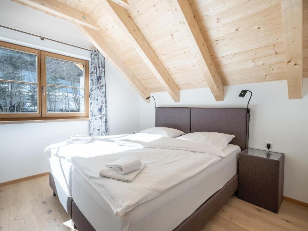 a bedroom with a large bed with white sheets at Haus Lilyan in Donnersbachwald