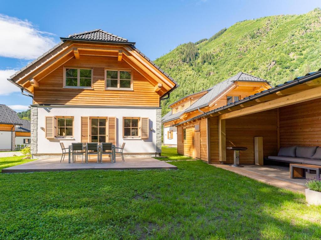 uma casa de madeira com um pátio e uma colina em Villa Petra em Donnersbachwald
