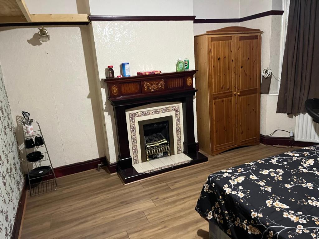 a living room with a fireplace and a bed at Leicester UK Fosse Park Shopping Centre Room 2 in Braunstone