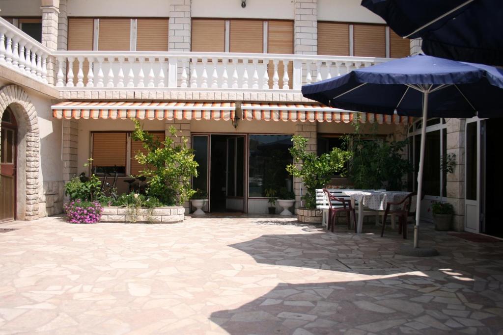 a patio with a table and an umbrella in front of a building at Apartments by the sea Jezera, Murter - 5123 in Jezera