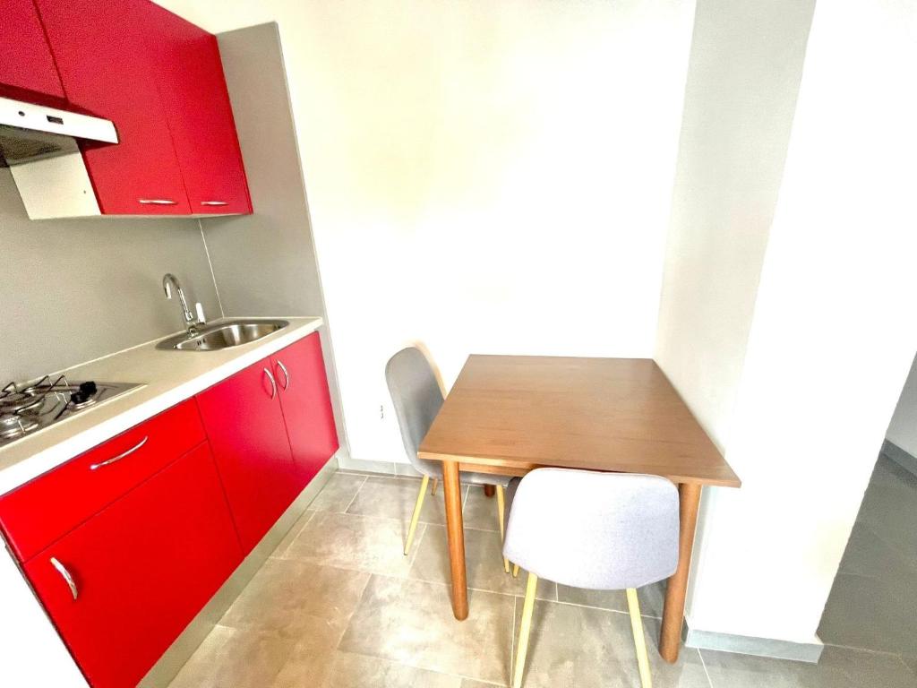 a small kitchen with a wooden table and red cabinets at Apartments by the sea Jezera, Murter - 5123 in Jezera