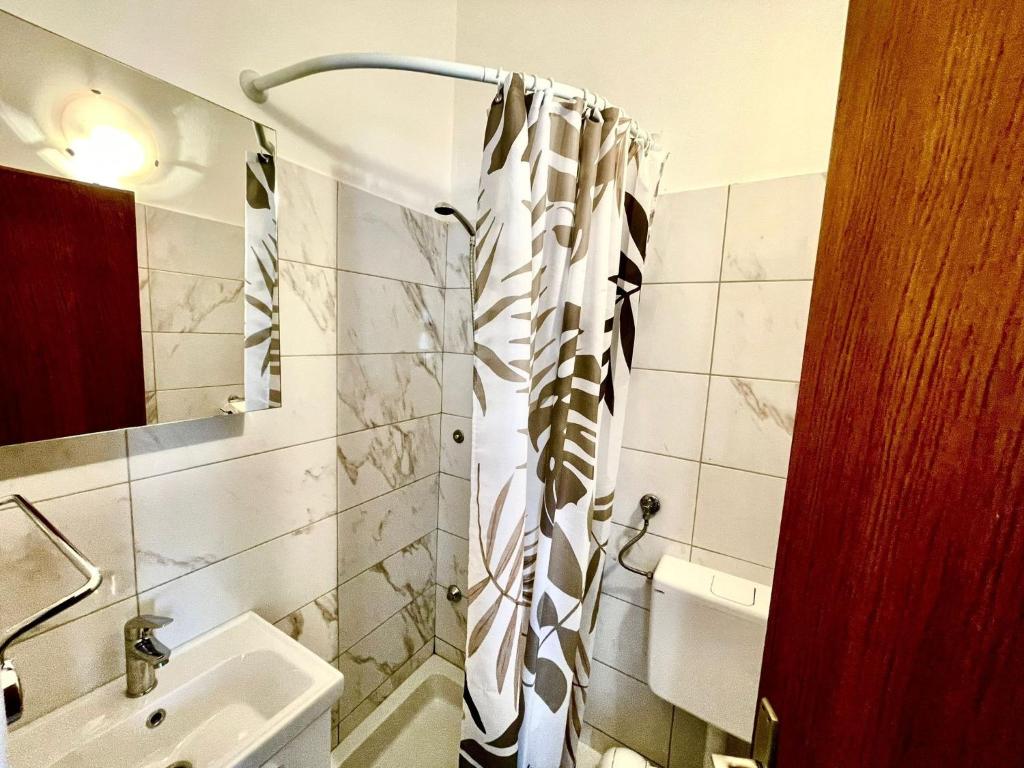 a bathroom with a shower curtain and a sink at Apartments by the sea Jezera, Murter - 5123 in Jezera