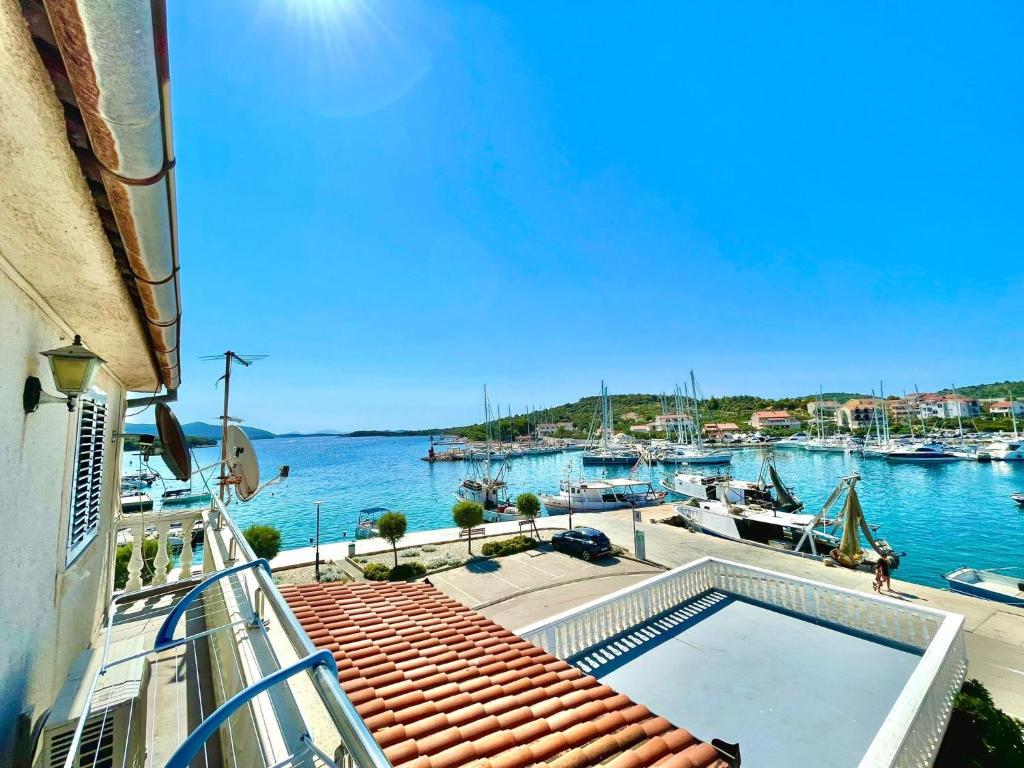 a balcony with a view of a marina with boats at Apartments by the sea Jezera, Murter - 5123 in Jezera