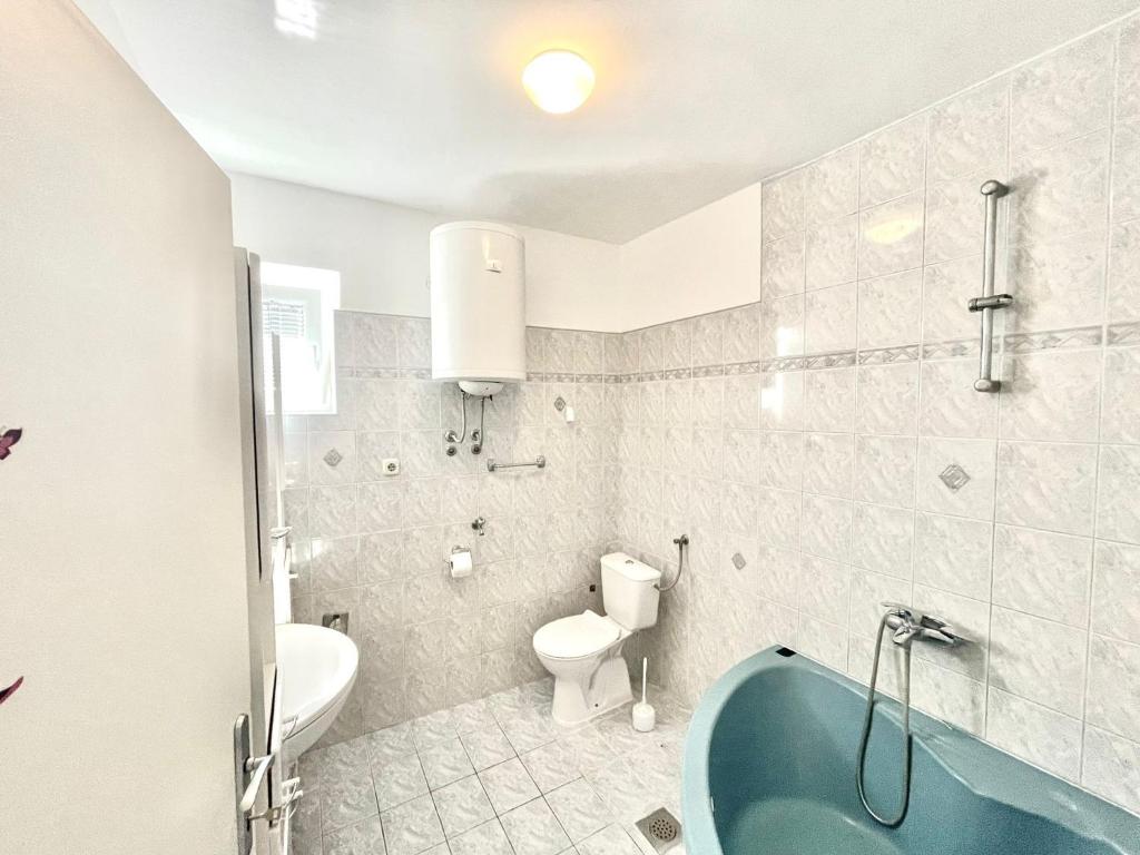 a bathroom with a tub and a toilet and a sink at Apartments by the sea Jezera, Murter - 5123 in Jezera