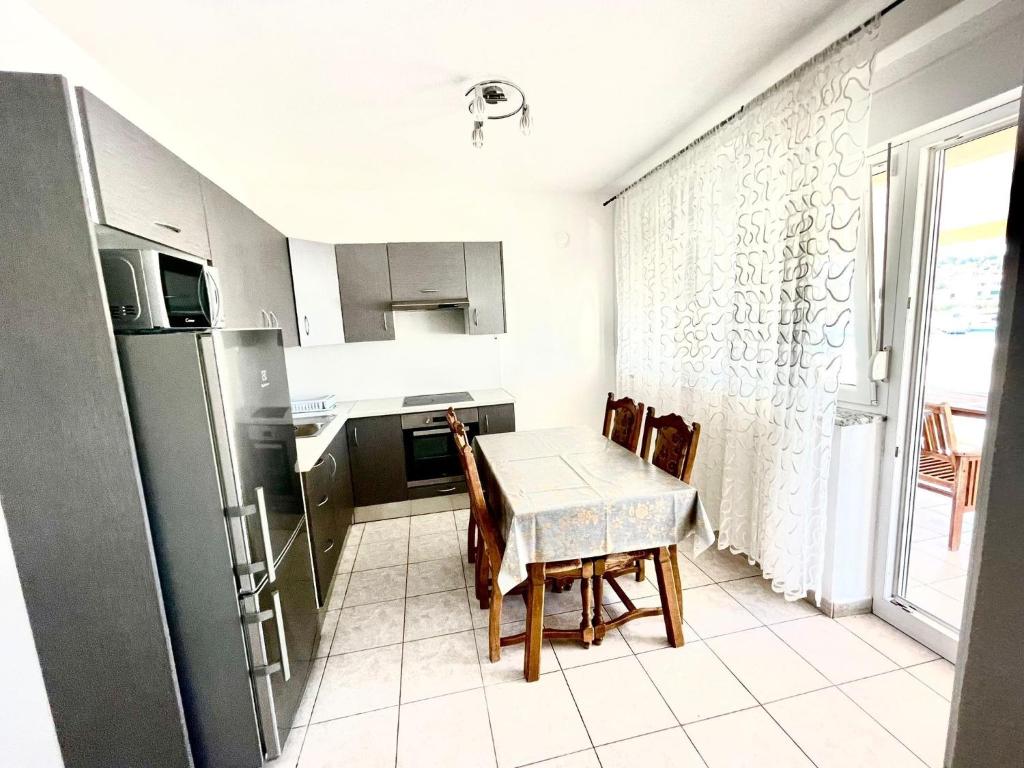 a kitchen with a table and chairs and a refrigerator at Apartments by the sea Jezera, Murter - 5123 in Jezera