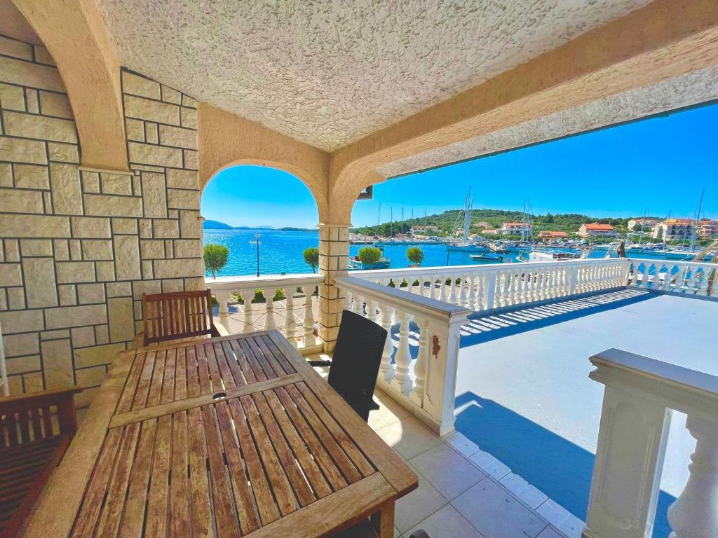 a porch with a table and a view of the water at Apartments by the sea Jezera, Murter - 5123 in Jezera