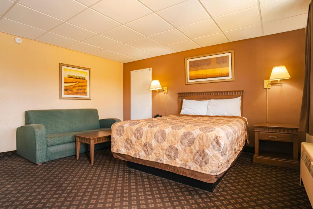 a hotel room with a bed and a chair at Faulds Motel in Sarnia