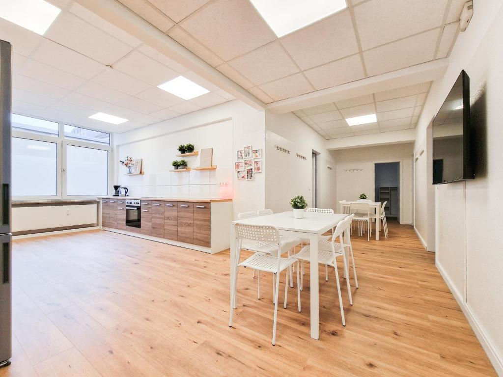 eine Küche und ein Esszimmer mit einem weißen Tisch und Stühlen in der Unterkunft RAJ Living - City Apartments with 5 Rooms - 10 Min Messe DUS in Düsseldorf