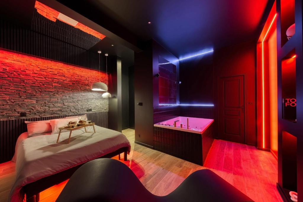 une chambre avec un lit, une baignoire et un lavabo dans l'établissement Suite Deluxe - Jacuzzi, à Melun