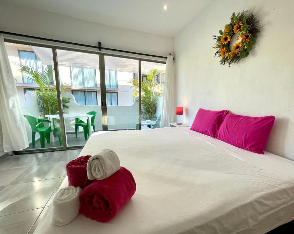 um quarto com uma grande cama branca com almofadas vermelhas em Miranda Beach em Playa del Carmen