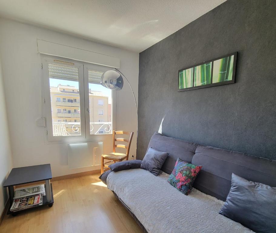 un salon avec un canapé et une chaise dans l'établissement Beautiful T3 with balcony - near beach, à Fréjus