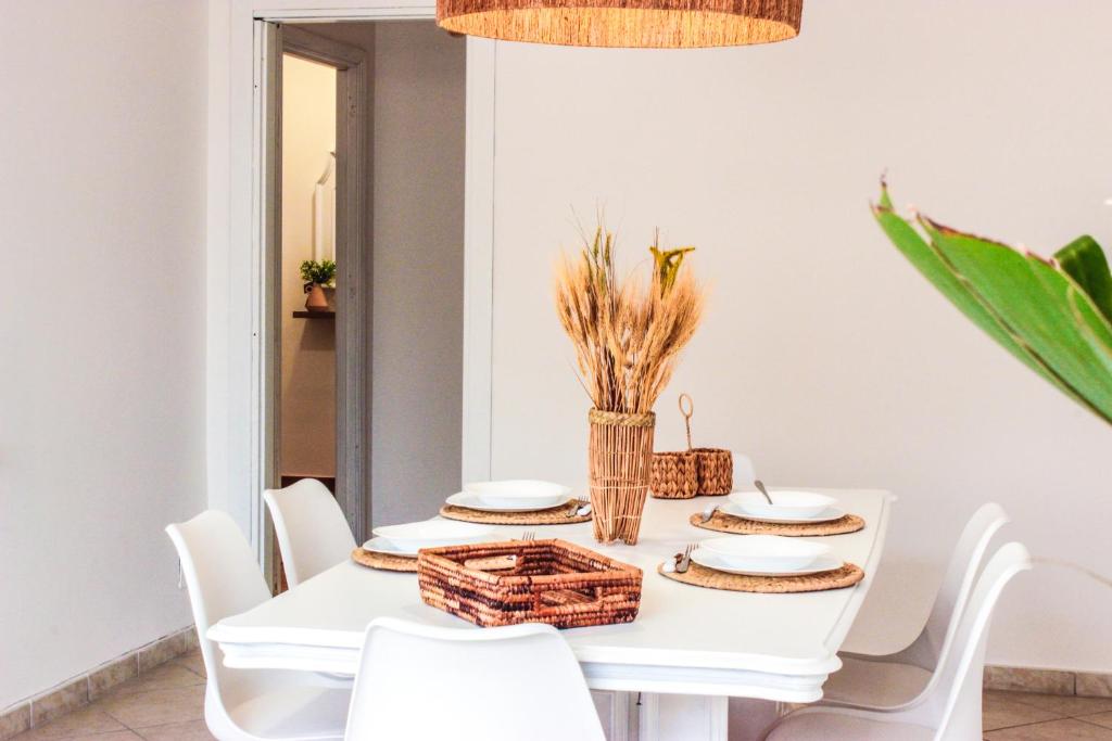 a white dining room with a white table with white chairs at Oltremare Suite N37 Villa fronte mare con spa privata giardino vista panoramica e wifi gratuito in Bagheria