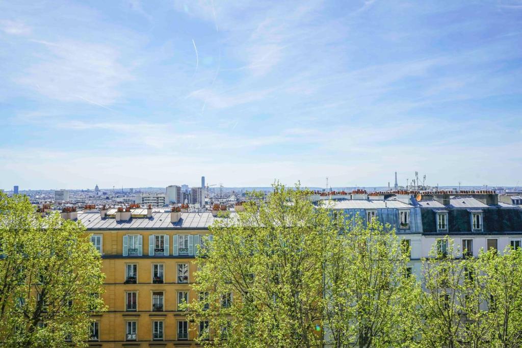 a view of a city with trees and buildings at Lovely cocoon with a view over Paris in Paris