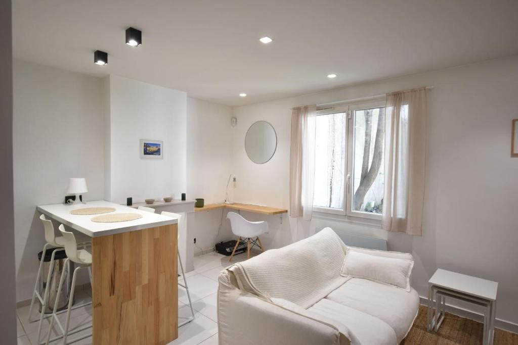 un salon avec un canapé blanc et une table dans l'établissement Nice 37 m with garden in Marseille, à Marseille