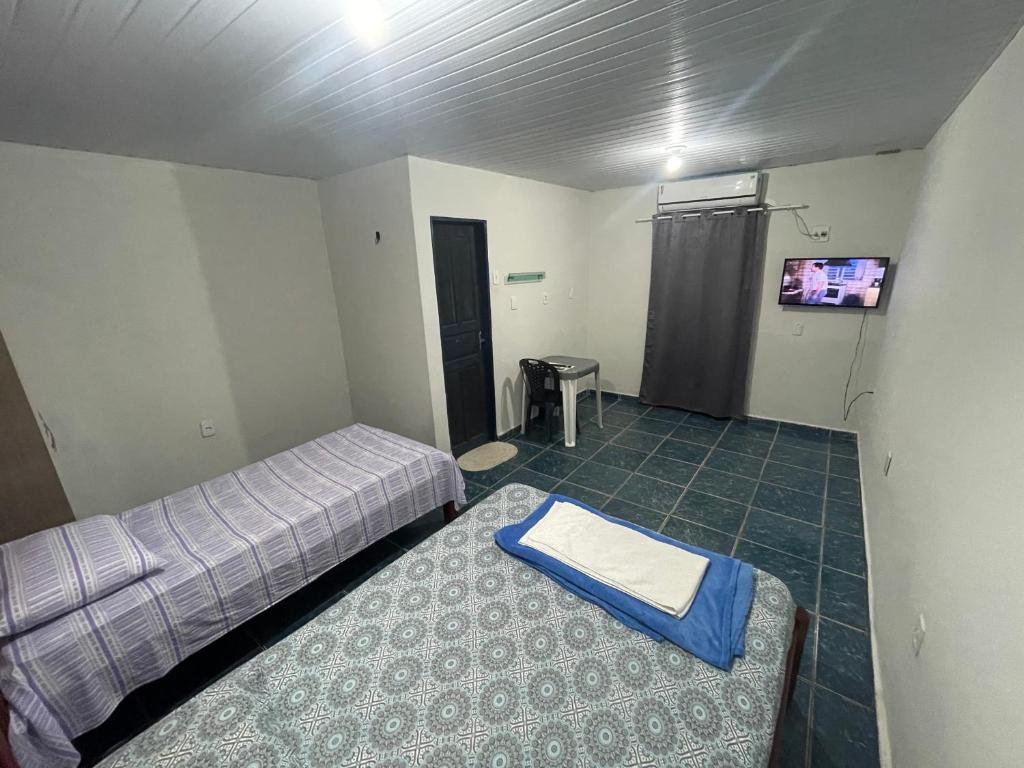 a room with two beds and a tv on the wall at Canto da Liberdade in Boa Vista