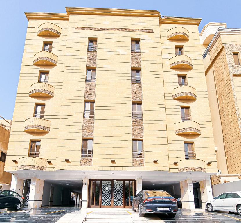 a large building with cars parked in front of it at HOMETEL An Nahdah in Jeddah