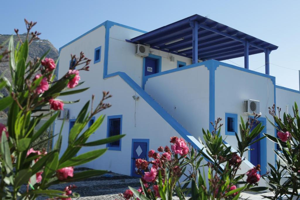 a building with blue doors and flowers at Studios Apartments Kapetanios in Perissa