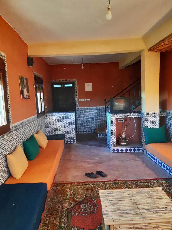 een woonkamer met een bank en een open haard bij Auberge Assays in Taliouine