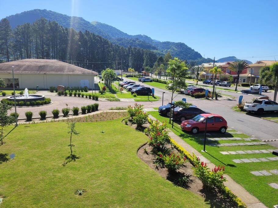 a park with cars parked in a parking lot at Apartamento com varanda Reserva do Sahy in Mangaratiba