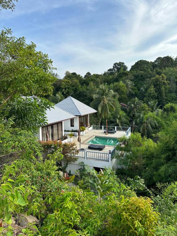 a house with a swimming pool in the middle of a forest at Luxurious Pool villa with great sea view in Ko Phangan