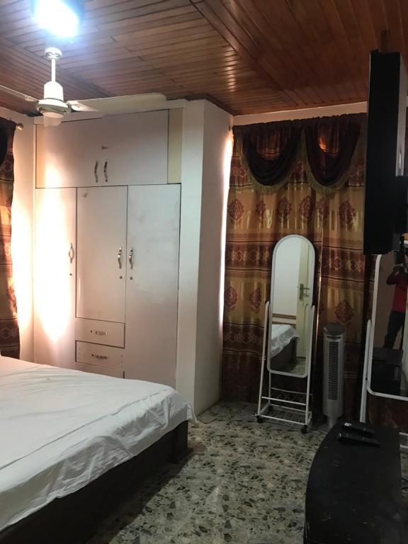 een slaapkamer met een bed en een spiegel bij King Makeri Guest House in Ogbojo