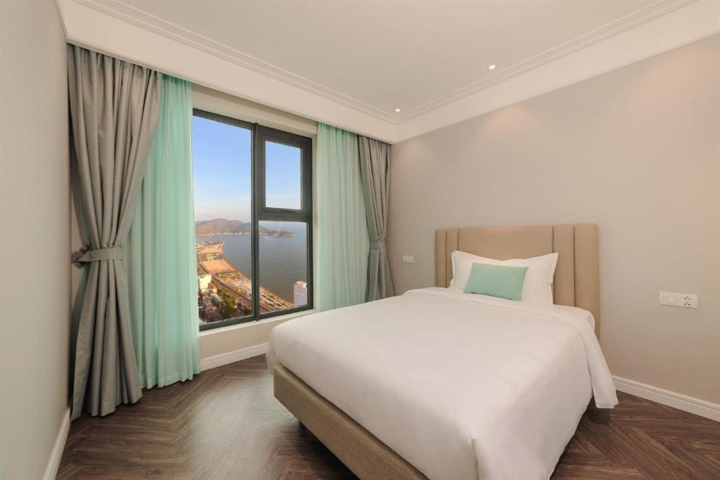 a bedroom with a large bed and a large window at Chuỗi Căn Hộ Khách Sạn Altara Residences Quy Nhơn in Quy Nhon